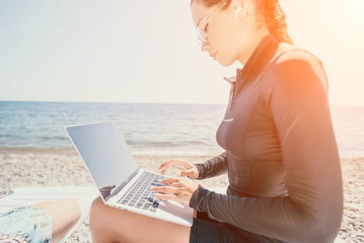 Digital nomad, Business man working on laptop by the sea. Man typing on computer by the sea at sunset, makes a business transaction online from a distance. Freelance, remote work on vacation