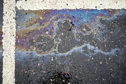 Oil Residue on Saturated Asphalt in a Parking Space with Division Markings.