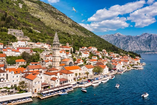 View of the historic town of Perast at famous Bay of Kotor on a beautiful sunny day with blue sky and clouds in summer, Montenegro. Historic city of Perast at Bay of Kotor in summer, Montenegro.