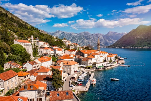View of the historic town of Perast at famous Bay of Kotor on a beautiful sunny day with blue sky and clouds in summer, Montenegro. Historic city of Perast at Bay of Kotor in summer, Montenegro.