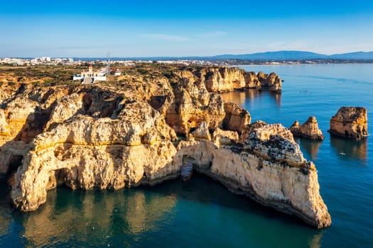 Panoramic view, Ponta da Piedade near Lagos in Algarve, Portugal. Cliff rocks and tourist boat on sea at Ponta da Piedade, Algarve region, Portugal. Ponta da Piedade, Algarve region, Portugal.