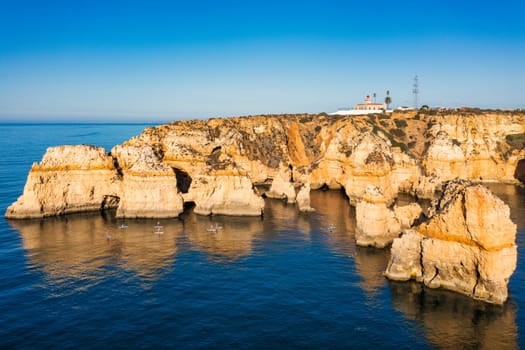 Panoramic view, Ponta da Piedade near Lagos in Algarve, Portugal. Cliff rocks and tourist boat on sea at Ponta da Piedade, Algarve region, Portugal. Ponta da Piedade, Algarve region, Portugal.