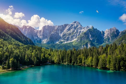 Picturesque lake Lago Fusine in Italy. Fusine lake with Mangart peak on background. Popular travel destination of Julian Alps. Location: Tarvisio comune , Province of Udine, Italy, Europe.