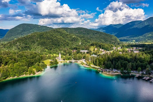 Aerial view of Bohinj lake in Julian Alps. Popular touristic destination in Slovenia. Bohinj Lake, Church of St John the Baptist. Triglav National Park, Julian Alps, Slovenia. 
