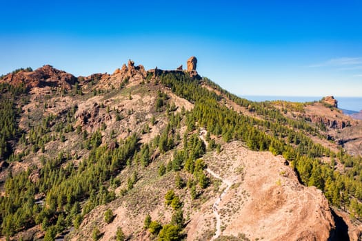 Roque Nublo and Pico de Teide in the background on Gran Canaria Island, Spain. Panoramic view of Roque Nublo sacred mountain, Roque Nublo Rural Park, Gran Canary, Canary Islands, Spain.