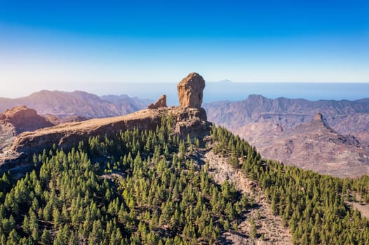 Roque Nublo and Pico de Teide in the background on Gran Canaria Island, Spain. Panoramic view of Roque Nublo sacred mountain, Roque Nublo Rural Park, Gran Canary, Canary Islands, Spain.