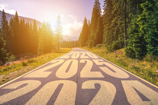 Empty asphalt road and New year 2024, 2025, 2026 concept. Driving on an empty road in the mountains to upcoming 2025, 2026 and leaving behind old years. Concept for success and passing time.