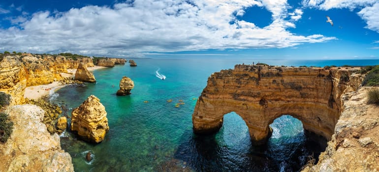 Praia da Marinha, beautiful beach Marinha in Algarve, Portugal. Navy Beach (Praia da Marinha) with flying seagulls over the beach, located on the Atlantic coast in Lagoa Municipality, Algarve.