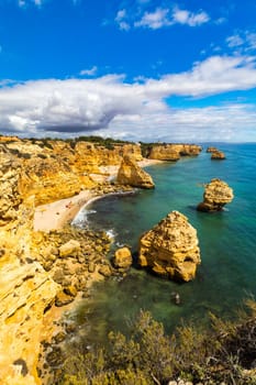 Praia da Marinha, beautiful beach Marinha in Algarve, Portugal. Navy Beach (Praia da Marinha) with flying seagulls over the beach, located on the Atlantic coast in Lagoa Municipality, Algarve.