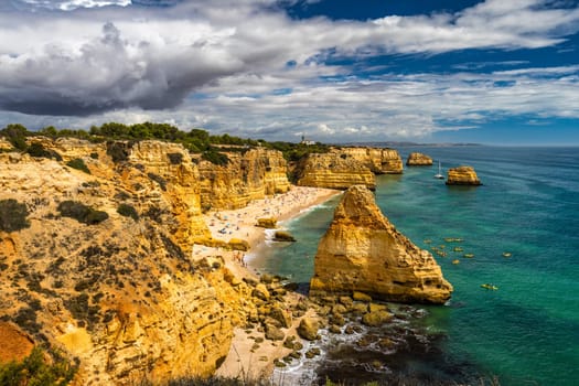 Natural caves at Marinha beach, Algarve Portugal. Rock cliff arches on Marinha beach and turquoise sea water on coast of Portugal in Algarve region. 