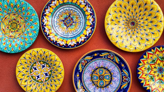 Collection of colorful Italian ceramic pottery, local craft products from Positano, Italy. Ceramic plates display in Positano, Italy. Colorful of vintage ceramic plates in Positano, Italy.