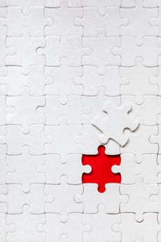 White jigsaw puzzle. White puzzle pieces on color background. Unfinished white jigsaw puzzle pieces on color background. 