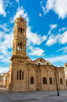A small building with a blue door sits in front of a large Mosque with a tall tower in Nicosia, Cyprus. Beautiful street with old architecture in Nicosia, Cyprus.