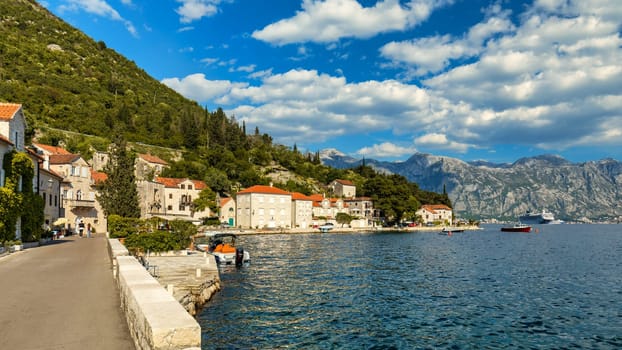 View of the historic town of Perast at famous Bay of Kotor on a beautiful sunny day with blue sky and clouds in summer, Montenegro. Historic city of Perast at Bay of Kotor in summer, Montenegro.