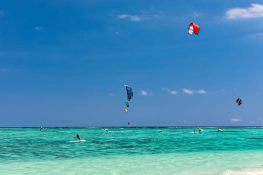 Kite surfers in the waters of Indian Ocean, Mauritius. Kite surfing in the clear waters of the Indian Ocean in Le Morne beach, Mauritius. Best Kite surfing experience at Mauritius island.