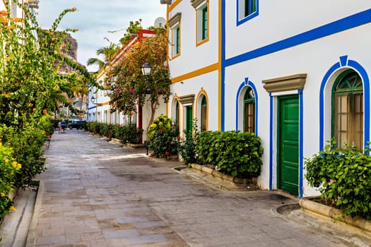 Street with blooming flowers in Puerto de Mogan, Gran Canaria, Spain. Favorite vacation place for tourists and locals on island. Puerto de Mogan with lots of bougainvillea flowers, Canary Island.