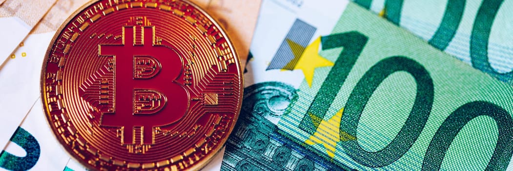Golden bitcoin over Euro money. Bitcoin cryptocurrency. Crypto currency concept. Bitcoin with euro bills. Bitcoins stacked on euro banknotes.