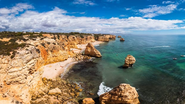 Praia da Marinha, beautiful beach Marinha in Algarve, Portugal. Navy Beach (Praia da Marinha) with flying seagulls over the beach, located on the Atlantic coast in Lagoa Municipality, Algarve.