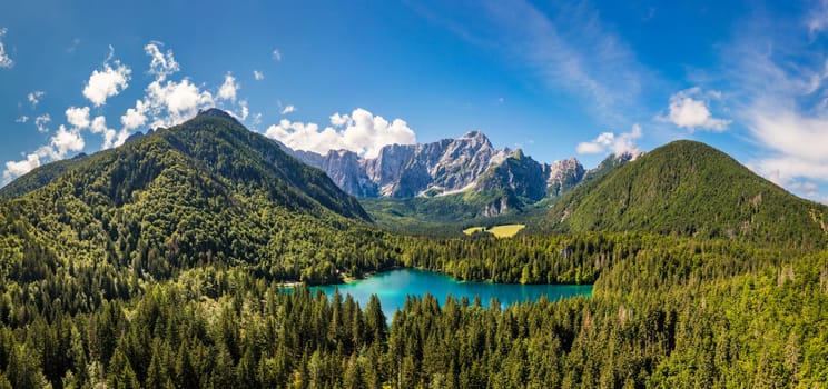 Picturesque lake Lago Fusine in Italy. Fusine lake with Mangart peak on background. Popular travel destination of Julian Alps. Location: Tarvisio comune , Province of Udine, Italy, Europe.