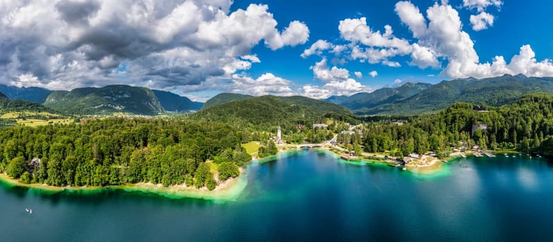 Aerial view of Bohinj lake in Julian Alps. Popular touristic destination in Slovenia. Bohinj Lake, Church of St John the Baptist. Triglav National Park, Julian Alps, Slovenia. 