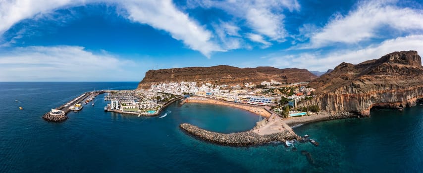 Puerto de Mogan with the beach in Gran Canaria, Spain. Favorite vacation place for tourists and locals on island. Harbor in Puerto de Mogan and Playa Mogan on Grand Canary Island, Spain.