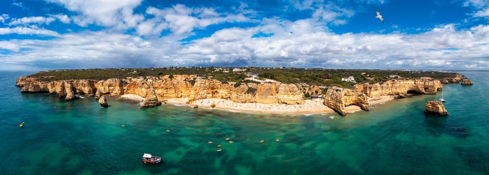 Praia da Marinha, beautiful beach Marinha in Algarve, Portugal. Navy Beach (Praia da Marinha) with flying seagulls over the beach, located on the Atlantic coast in Lagoa Municipality, Algarve.