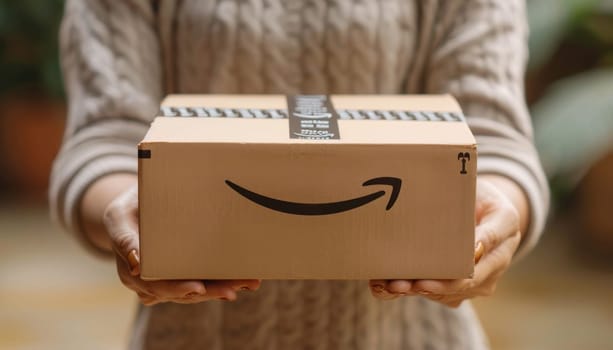 Woman holding an amazon package delivered to her home