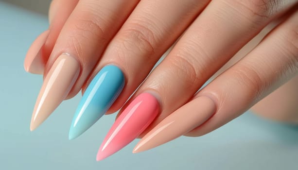 Woman hand with stylish trendy ombre gradient manicure design on blue background