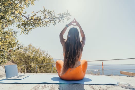 Fitness woman sea. Outdoor workout on yoga mat in park near to ocean beach. Female fitness pilates yoga routine concept. Healthy lifestyle. Happy fit woman exercising with rubber band in park.