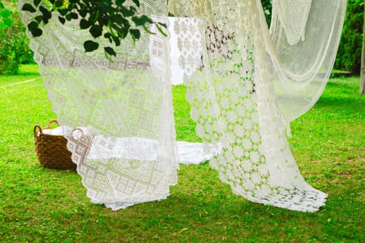 Washing day with laundry on clothesline, White clean sheets outdoors. Drying on a rope on background of beautiful scenery in the sun