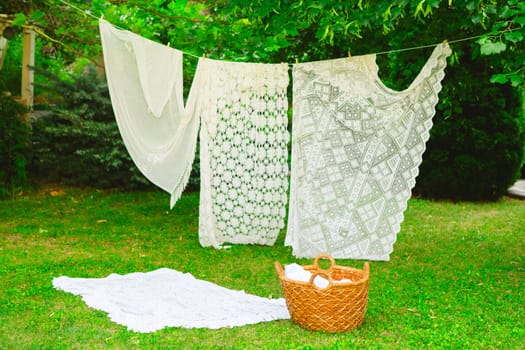 Washing day with laundry on clothesline, White clean sheets outdoors. Drying on a rope on background of beautiful scenery in the sun