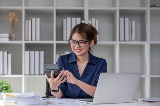 Young accountant uses a calculator to calculate taxes and manage business accounts in the office..