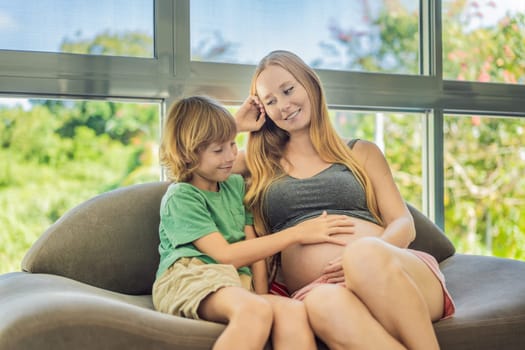 A heartwarming moment: pregnant mother and her older son sit on the sofa, engaging in a tender conversation about the upcoming pregnancy.