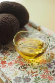 oil and slice of avocado on wooden table .