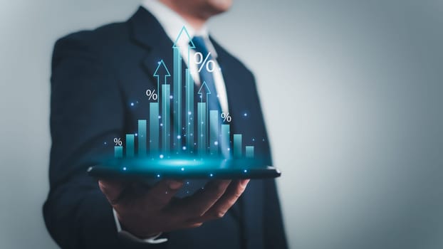 Businessman is holding a tablet to display a graph with percentage signs for the future growth plan of his organization. Finance, management, plan, management, strategy.