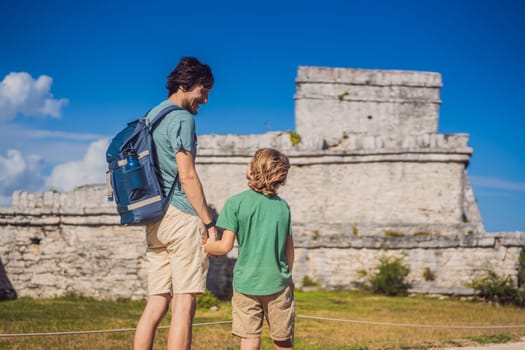 Father and son tourists enjoying the view Pre-Columbian Mayan walled city of Tulum, Quintana Roo, Mexico, North America, Tulum, Mexico. El Castillo - castle the Mayan city of Tulum main temple.