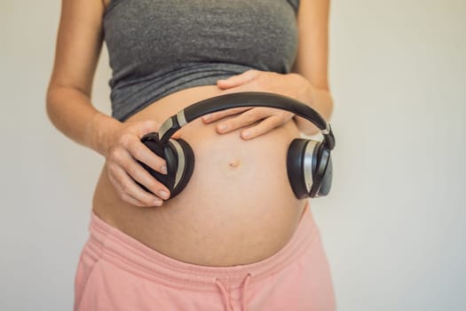 Melodies in the womb: Headphones placed on a pregnant belly, bonding through music, a heartwarming connection between mother and baby.