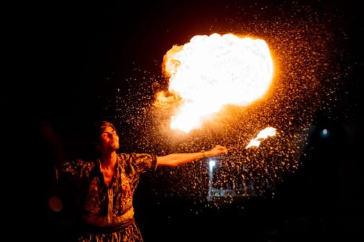 Jaisalmer, Rajasthan, India - 23rd Dec 2023: Young man in traditional rajasthan dress eating, breathing fire performance spitting showing talent and risk