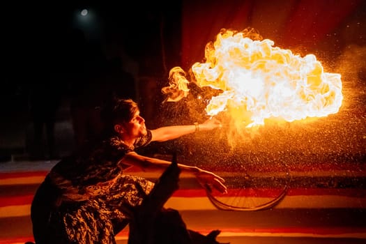 Jaisalmer, Rajasthan, India - 23rd Dec 2023: Young man in traditional rajasthan dress eating, breathing fire performance spitting showing talent and risk
