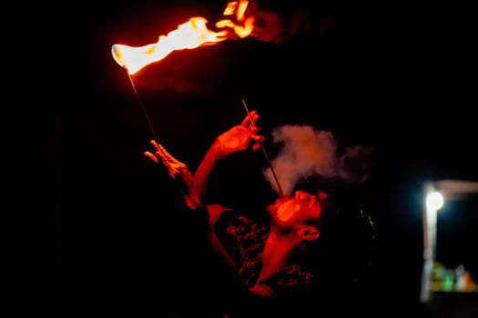 Jaisalmer, Rajasthan, India - 23rd Dec 2023: Young man in traditional rajasthan dress eating, breathing fire performance spitting showing talent and risk