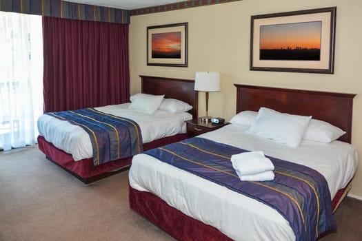 Two made up beds in a hotel room
