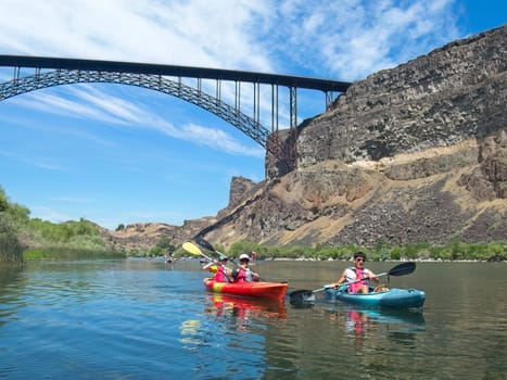 A vacationing family is kayaking on the Snake River near the Perrine Bridge in Twin Falls, Idaho.