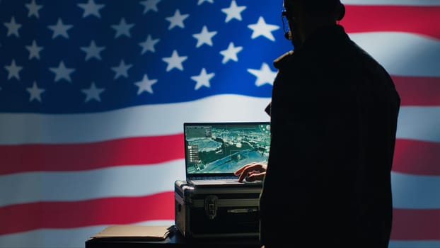US Air Force agent using radar system on laptop to detect incoming ballistic missiles. American NATO army soldier scanning rockets approaching borders, deploying shields, United States flag, camera A