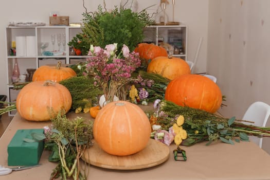 Flower arrangement in a pumpkin, autumn interior decor. Creating handmade autumn decor