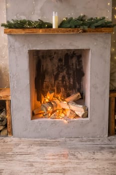 Fireplace decorated for Christmas. The interior of the Scandinavian-style living room, decorated for the Christmas holidays