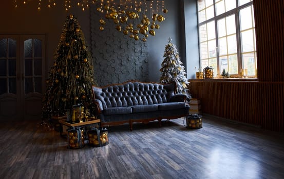 Luxurious interior of the room for Christmas and New Year. Living room in gray and gold tones with a sofa, many gifts, golden balls, ice lights, two Christmas trees