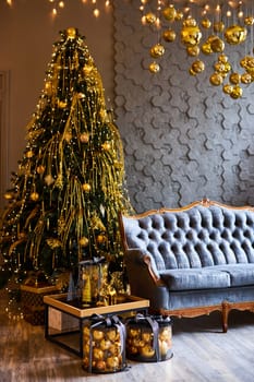Luxurious interior of the room for Christmas and New Year. Living room in gray and gold tones with a sofa, many gifts, golden balls, ice lights, two Christmas trees