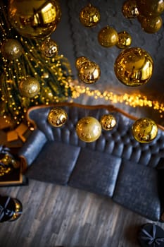 Luxurious interior of the room for Christmas and New Year. Living room in gray and gold tones with a sofa, many gifts, golden balls, ice lights, two Christmas trees. Extreme high angle shooting