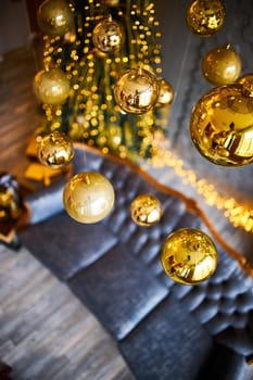 Luxurious interior of the room for Christmas and New Year. Living room in gray and gold tones with a sofa, many gifts, golden balls, ice lights, two Christmas trees. Extreme high angle shooting