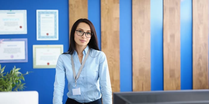 Beautiful young businesswoman is standing in the office, close-up, blurry. ISO certification. Quality management specialist